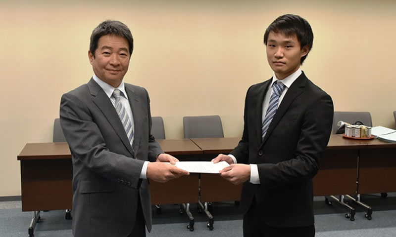少林寺拳法部を代表して支援奨励金証書を受け取る北川樹さん（右）。左は藤木英幸・同窓会会長