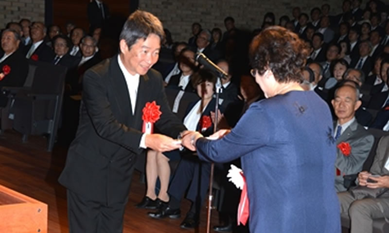 開学記念式典で谷本理事長に記念品の目録を手渡す藤木会長